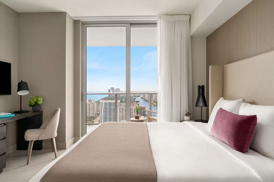 Rest easy in a serene bedroom with scenic high-rise views.