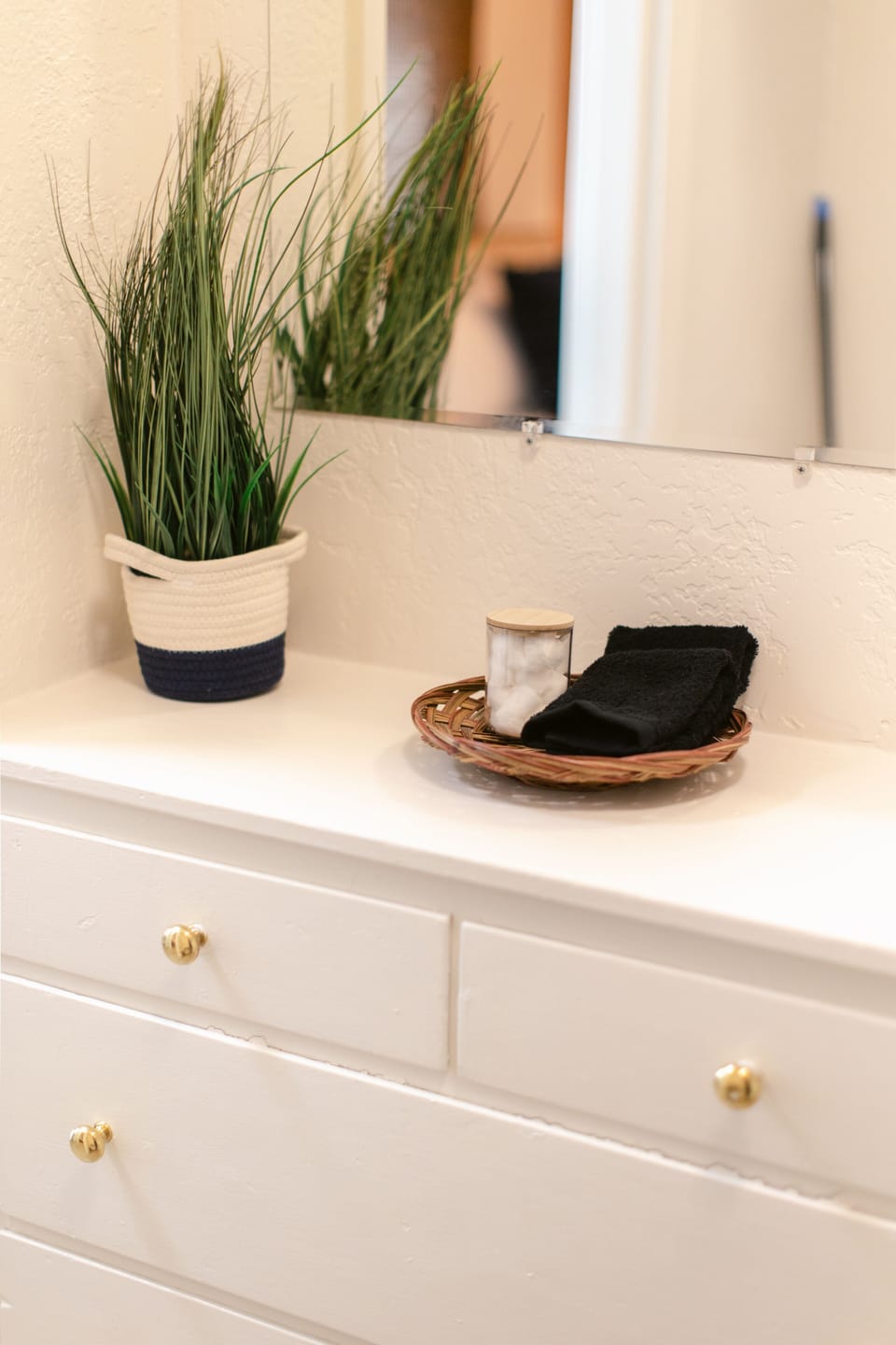 Arrangement of greenery and essentials on a sleek dresser.