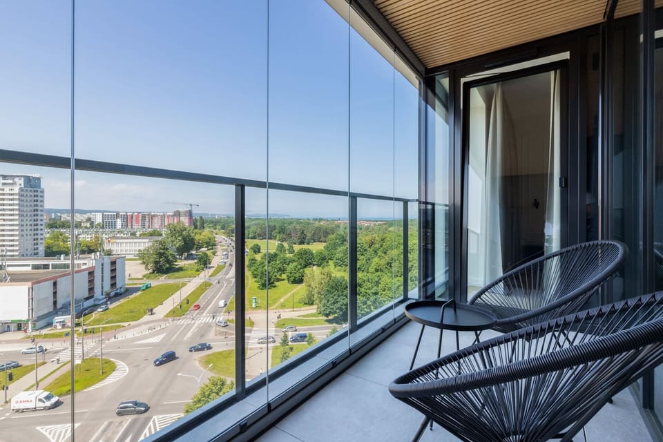 Furnished balcony with a small table, two chairs and a nice view of the city.