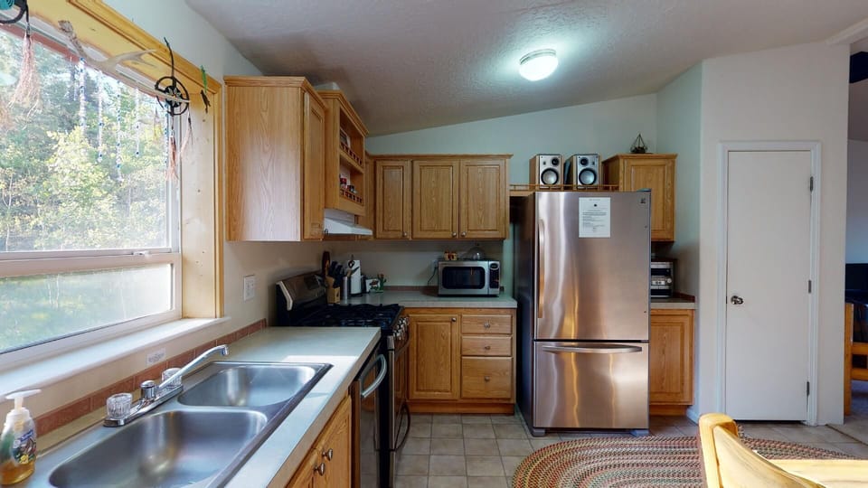 Equipped with stainless steel appliances, basic cooking essentials, and cookware.