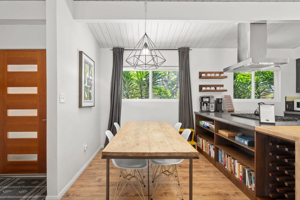 Gather around the dining table in this bright, modern space with a fully equipped kitchen and lush tropical views—perfect for shared meals and morning coffee.