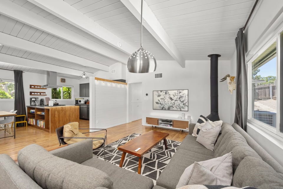 Relax in your spacious open-concept living area with soaring vaulted ceilings, modern furnishings, and warm natural light streaming through large windows—your perfect home away from home awaits.