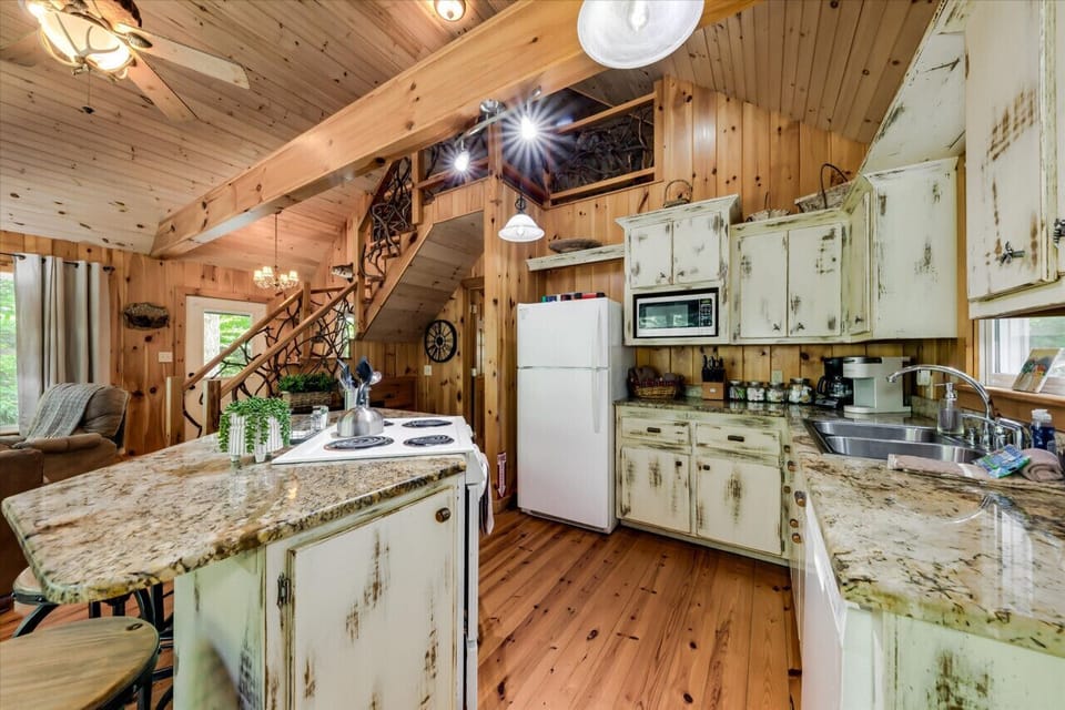 Main cabin kitchen island, cabinets, dishwasher, oven, stove and fridge.