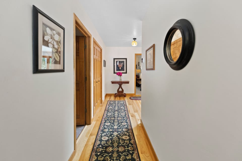 Hallway from entrance to living room, full bath doorway at left.
