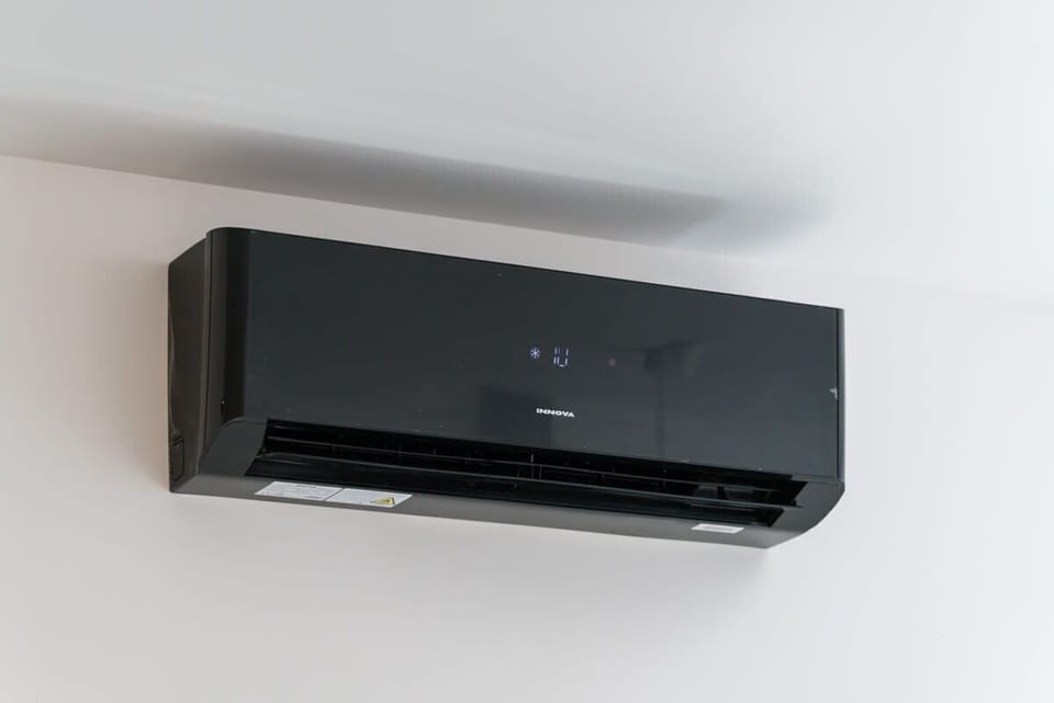 A close-up of a sleek black air conditioning unit installed in the living area.