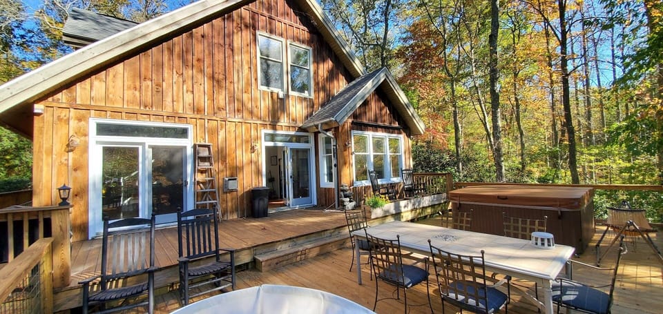 Back deck with hot tub, projector screen and outside dining table.