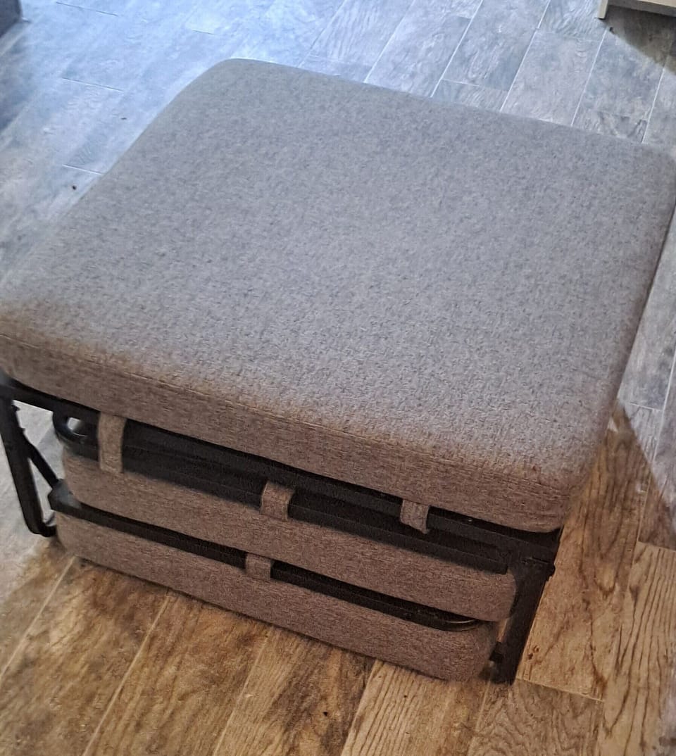 Ottoman in living room that makes into twin bed. 