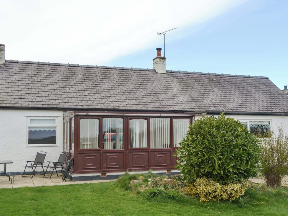 Rear of property with patio and conservatory | Pen Parc, Rhosybol, near Amlwch