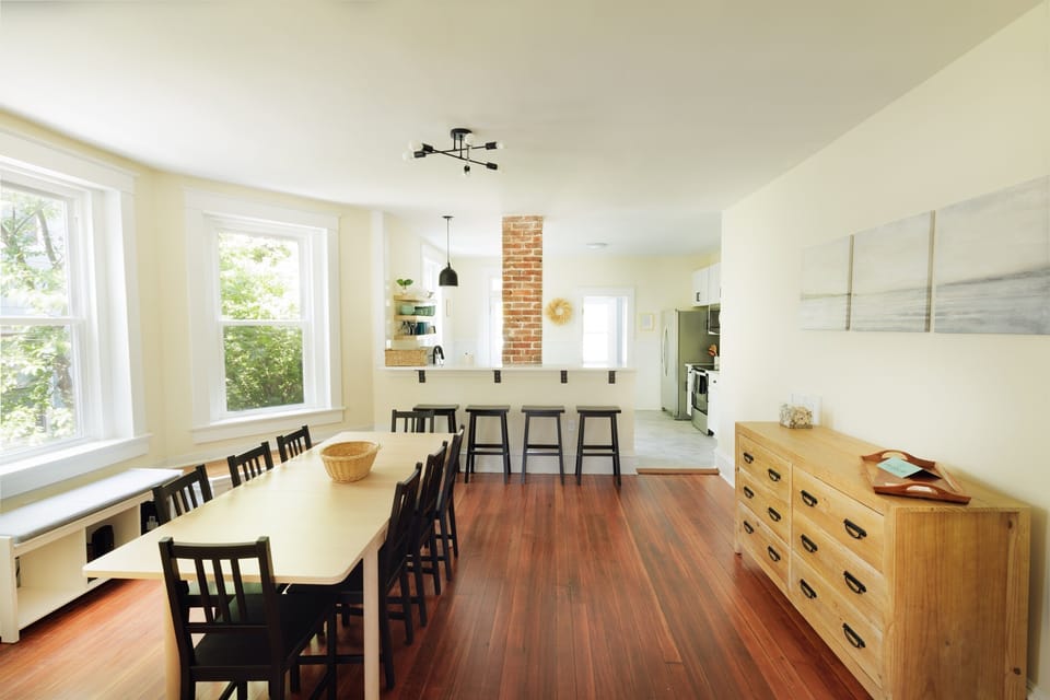 Large dining area with seating for eight at the kitchen table and four at the bar.