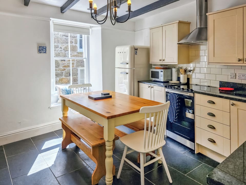 There is a large farmhouse style kitchen table in the kitchen/diner | Oaken Cottage, Mousehole, Penzance