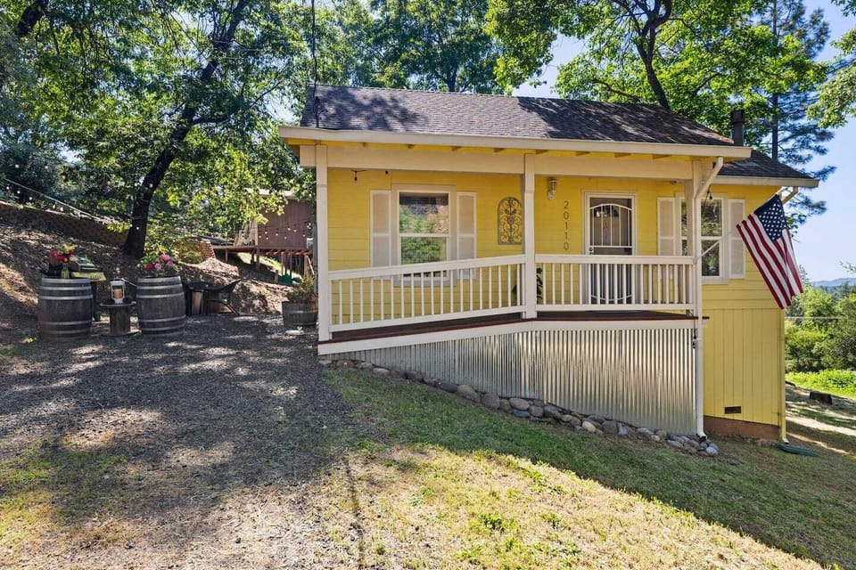 Front of Brodie Cabin with a covered porch overlooking the peaceful yard where deer and wild turkeys often wander. A serene Tuolumne mountain retreat and perfect Yosemite gateway for families and couples.