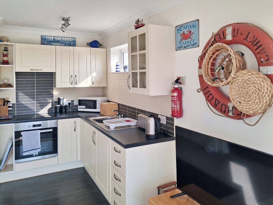 Well appointed fitted kitchen with a nautical flavour. | Upper Deck - Linden Court Apartments, Brixham