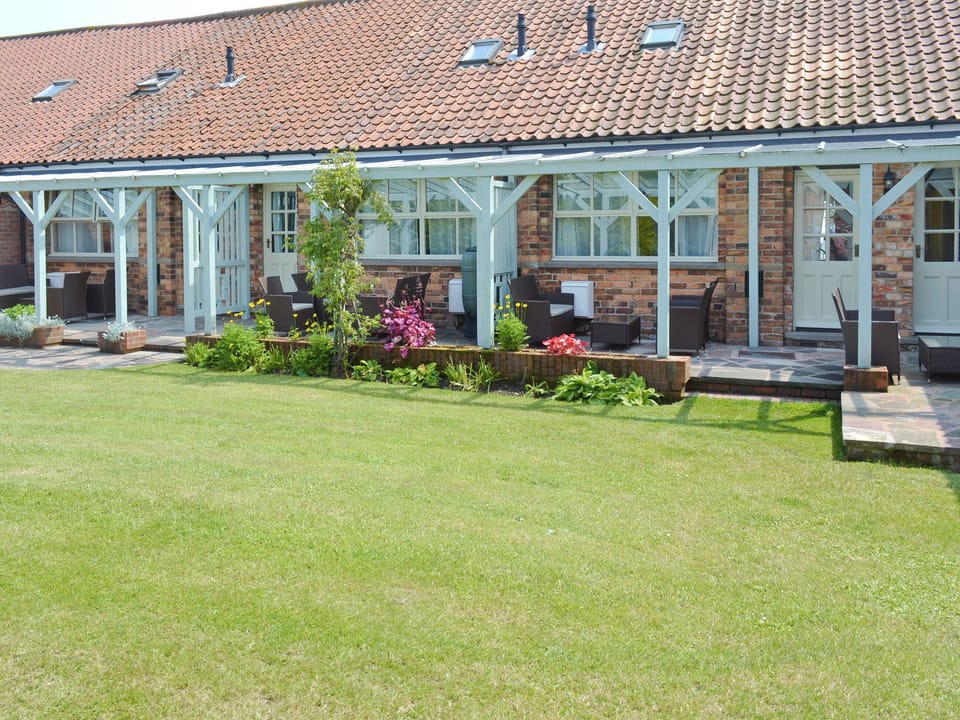 Rear lawned garden with covered patio | Lavender Cottage - Barmoor Farm Cottages, Scalby, near Scarborough