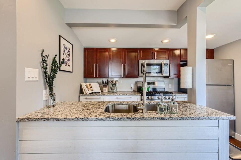 Full kitchen with double sink, quartz counters and gas convection range oven