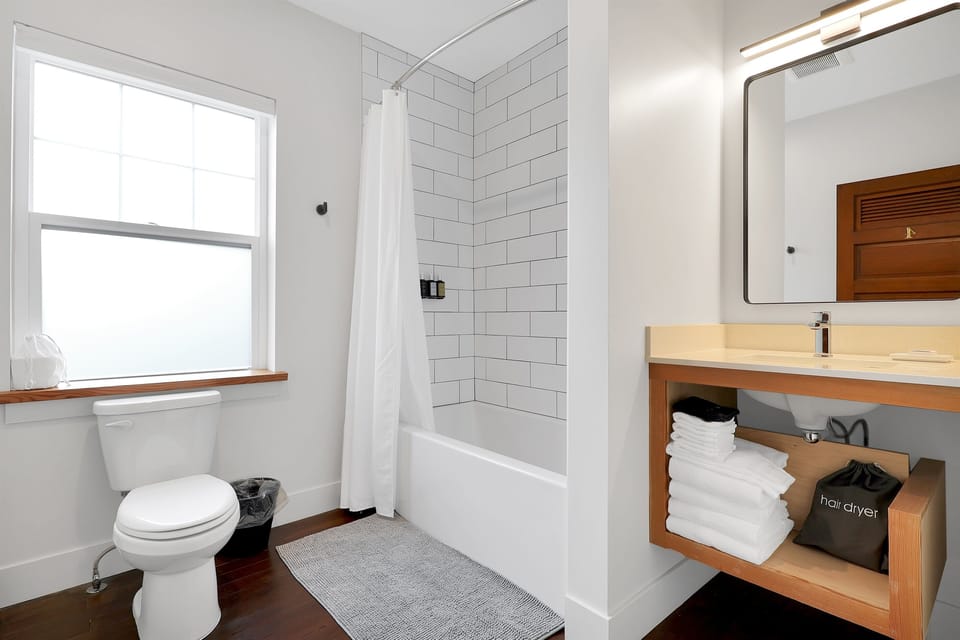 Deep modern bathtub, custom tile & stone countertops.