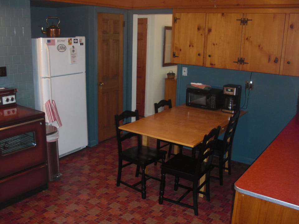 Eat-in kitchen has full-sized fridge with ice-maker.