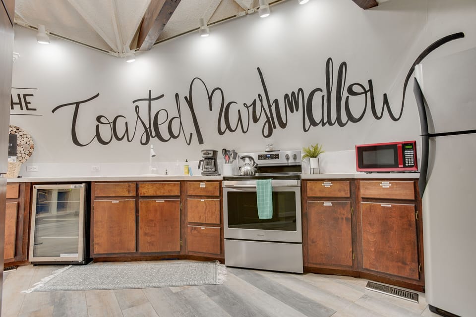 The kitchen space has a hand painted wall mural spreading across the entire kitchen wall.