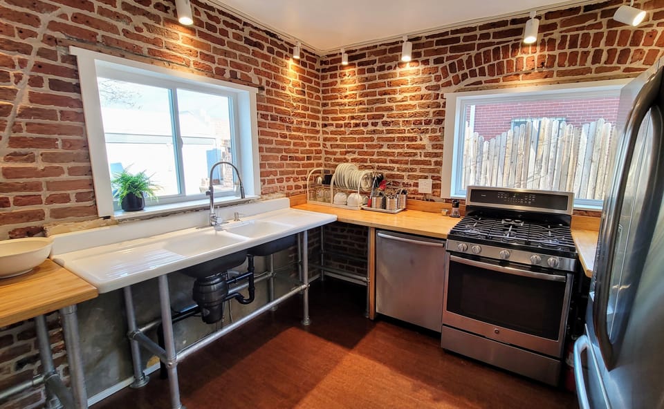 Custom counters surround the vintage farm sink, lighting accents the 