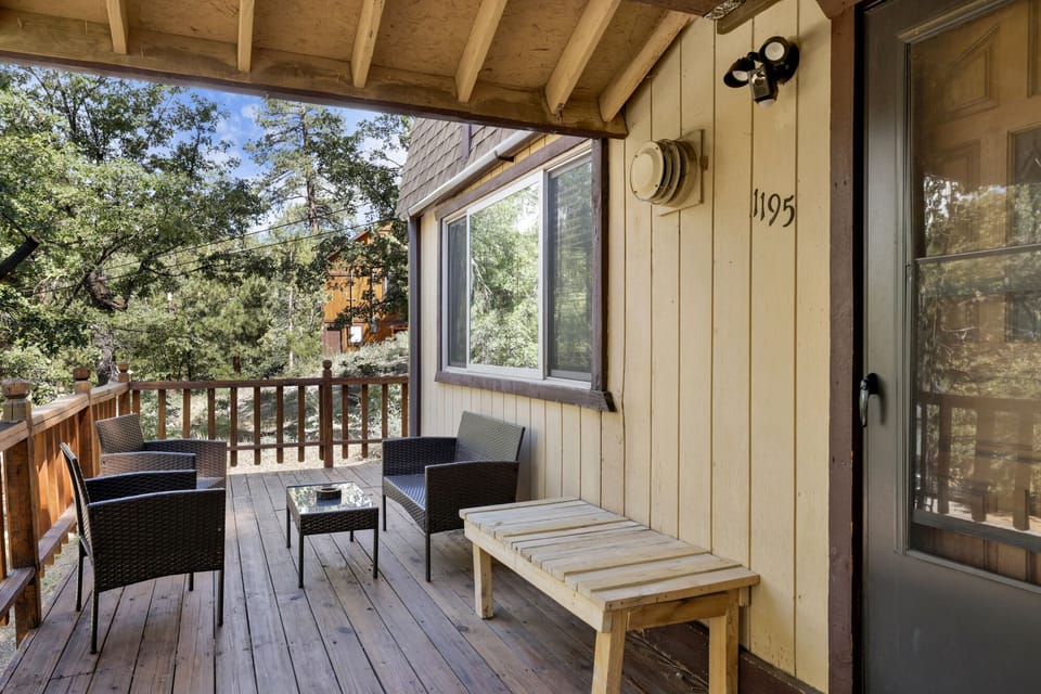 Welcoming cabin entry surrounded by towering pine trees, offering fresh mountain air and a peaceful forest setting—the perfect first impression for your Big Bear Lake getaway.