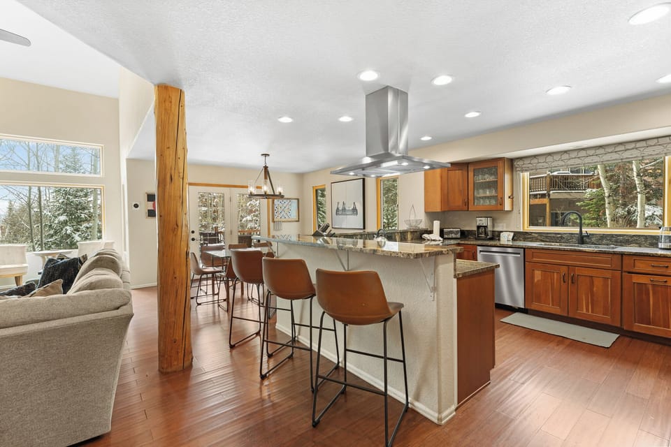 Gather around the spacious kitchen island where morning coffee and conversation flow effortlessly. Natural light pours through expansive windows, warming the hardwood floors and inviting you to feel completely at home.