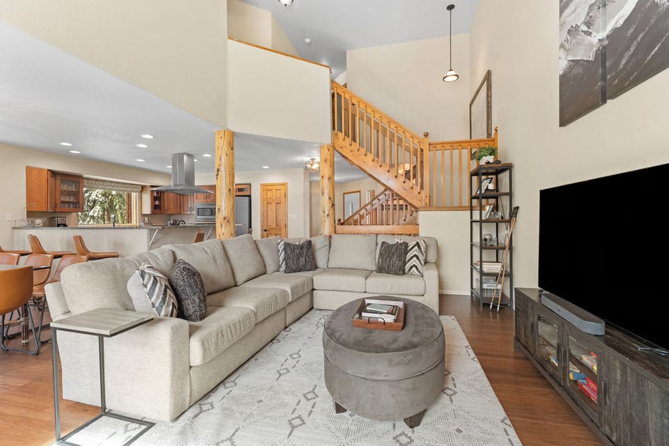 Settle in and unwind in this inviting open-concept retreat, where vaulted ceilings, warm wood accents, and a cozy sectional create the perfect space for relaxing evenings with mountain views just beyond.