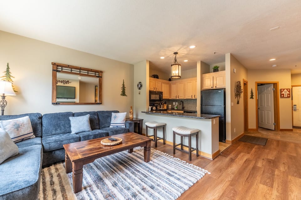 Spacious living area with mounted flat screen TV, hardwood flooring, gas fireplace and access to the private balcony.