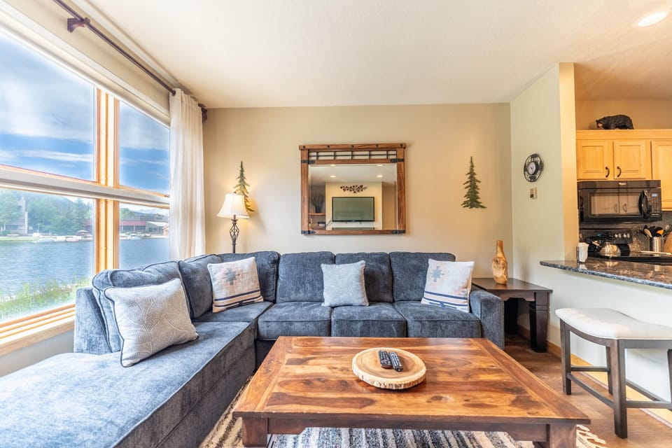 Spacious living area with mounted flat screen TV, hardwood flooring, gas fireplace and access to the private balcony.