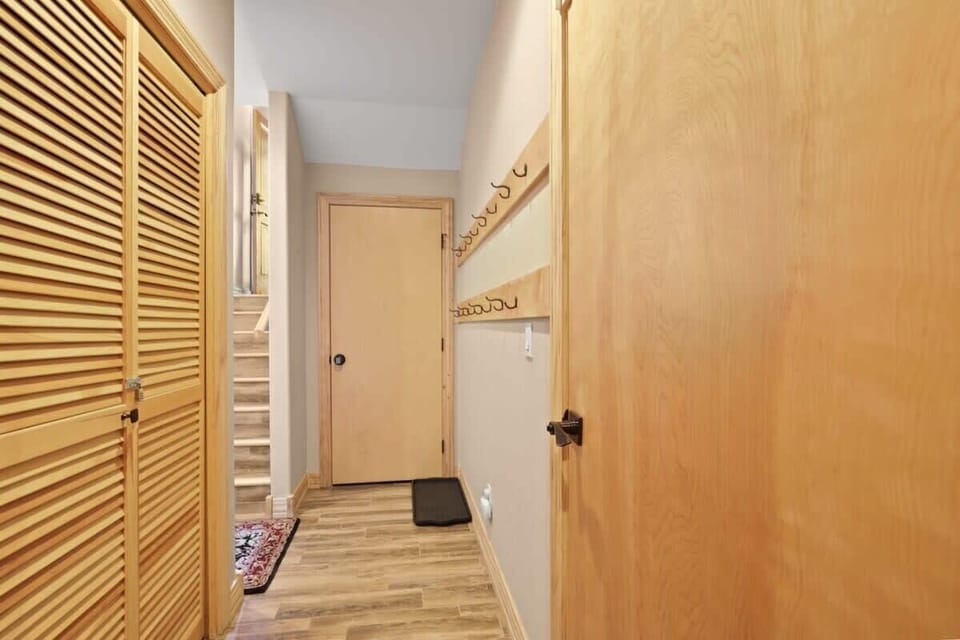 The downstairs hallway just off of the garage has a boot tray and rows of hooks where you can hang your gear as well as a laundry closet with a front-loading washer and dryer.