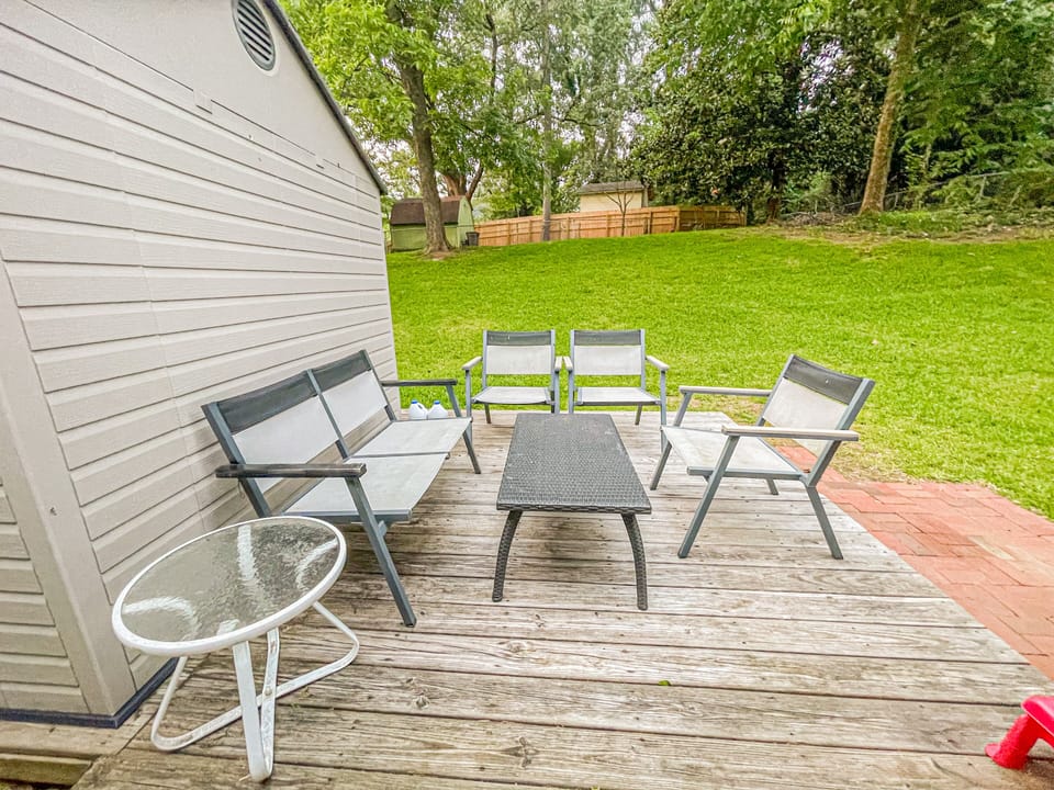 Lush fenced-in backyard with patio furniture for sweet summer afternoon