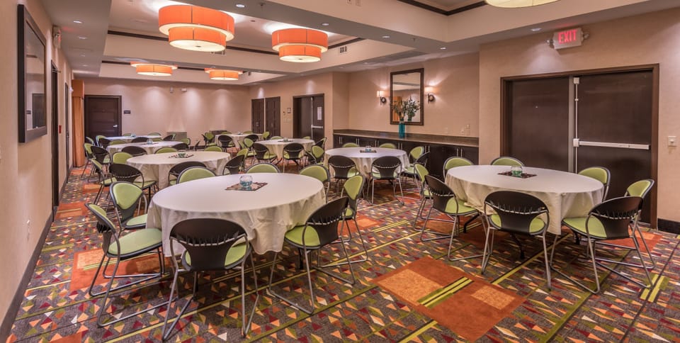 Meeting room with rectangular tables and chairs.