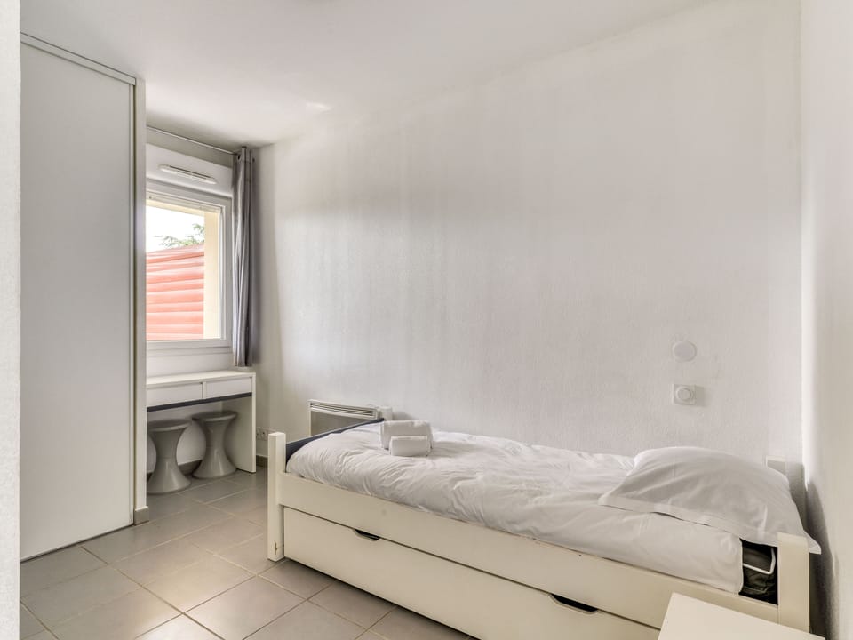 The tranquil bedroom showcases a simple yet stylish design with a comfortable single bed, providing a restful oasis perfect for unwinding after a day of exploration.