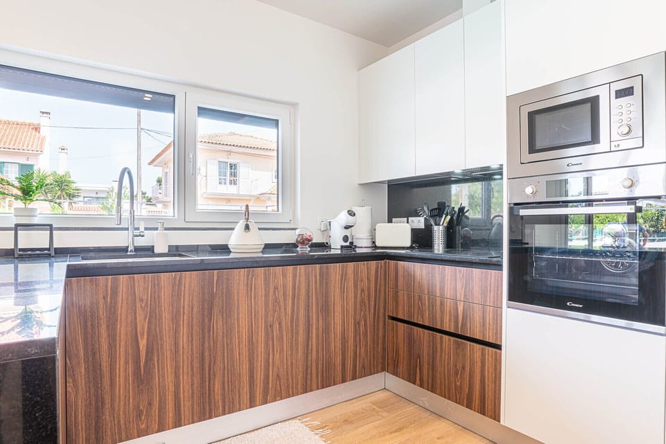 Modern kitchen with dark granite countertops and wood cabinetry — Villa Cuca, holiday villa in Marisol
