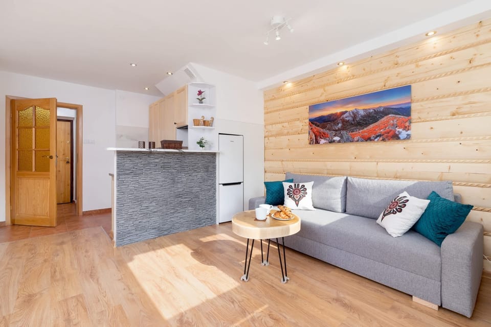 A bright and spacious open-plan area with a well-equipped kitchenette, dining table, and comfortable seating, perfect for both relaxation and meals.





