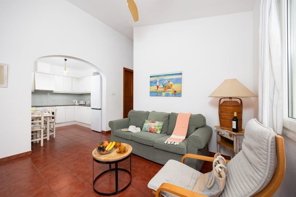Open-plan living room with sofa, dining area, kitchen, WiFi internet, and satellite TV