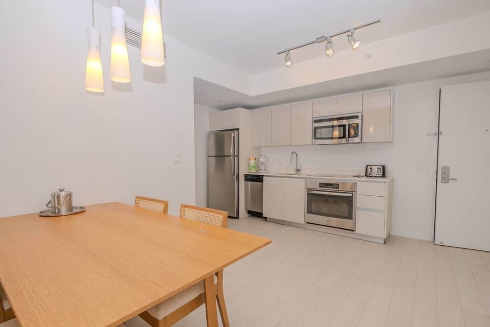 Gather around the stylish dining area in this beautifully designed Beachwalk apartment in Hallandale Beach. Ideal for enjoying home-cooked meals with a view of the vibrant city skyline.