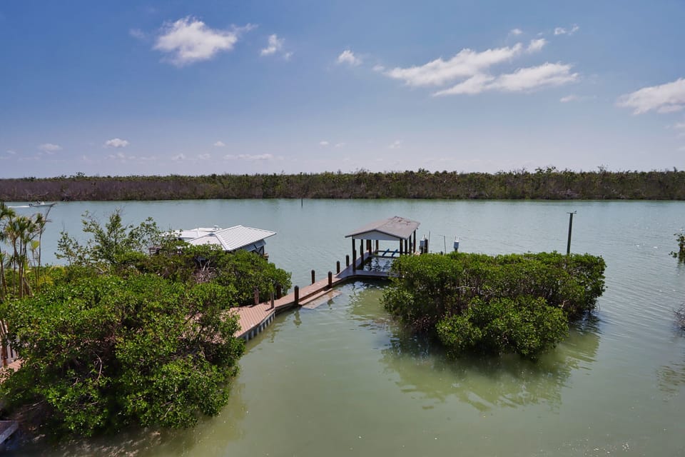 View from primary bedroom balcony overlooking boat dock and the Roosevelt Channel