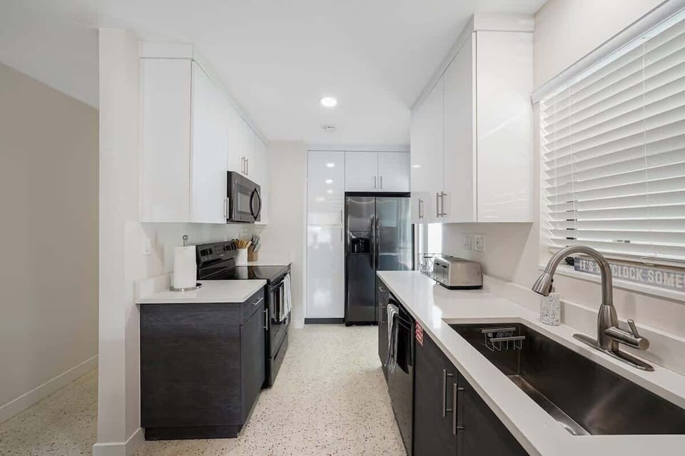 The kitchen is stocked with a full set of appliances including a Keurig and basic kitchen utensils. 