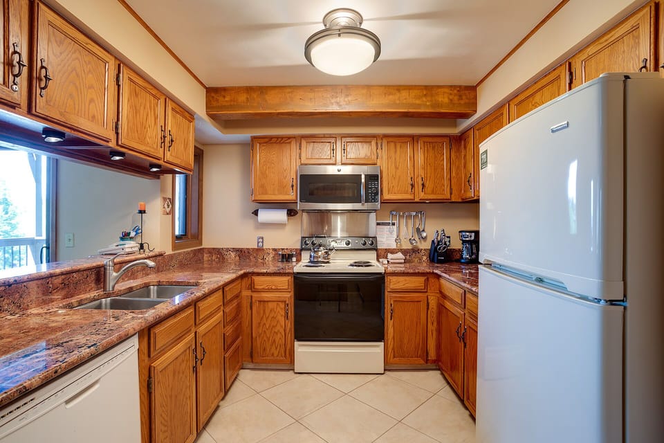 Your fully equipped kitchen awaits with warm oak cabinets, granite counters, and everything you need to create memorable meals during your stay.
