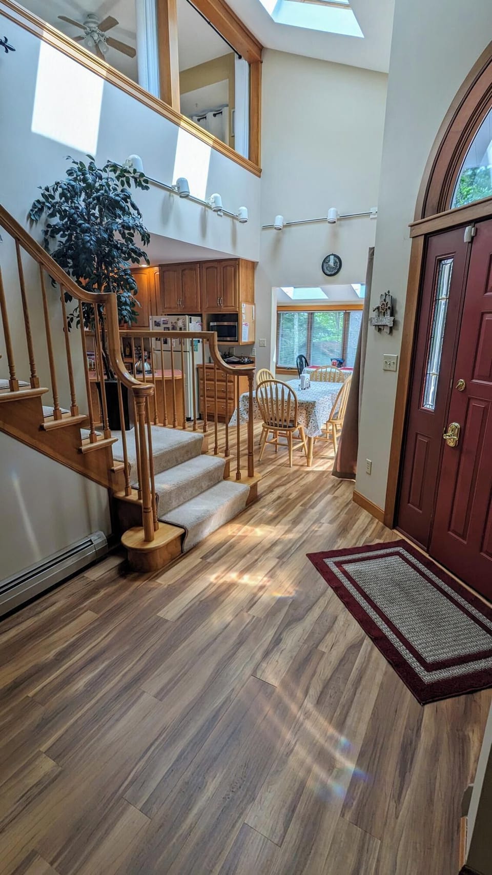 This pictures shows you the main entrance door to your right, the main stairway leading upstairs as well as the kitchen and little dining area/sunroom.