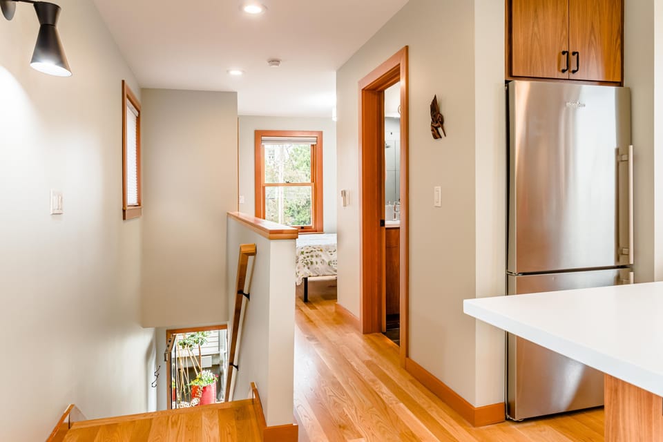 Looking toward bathroom and sleeping area beyond.  Stairway to down to entry.