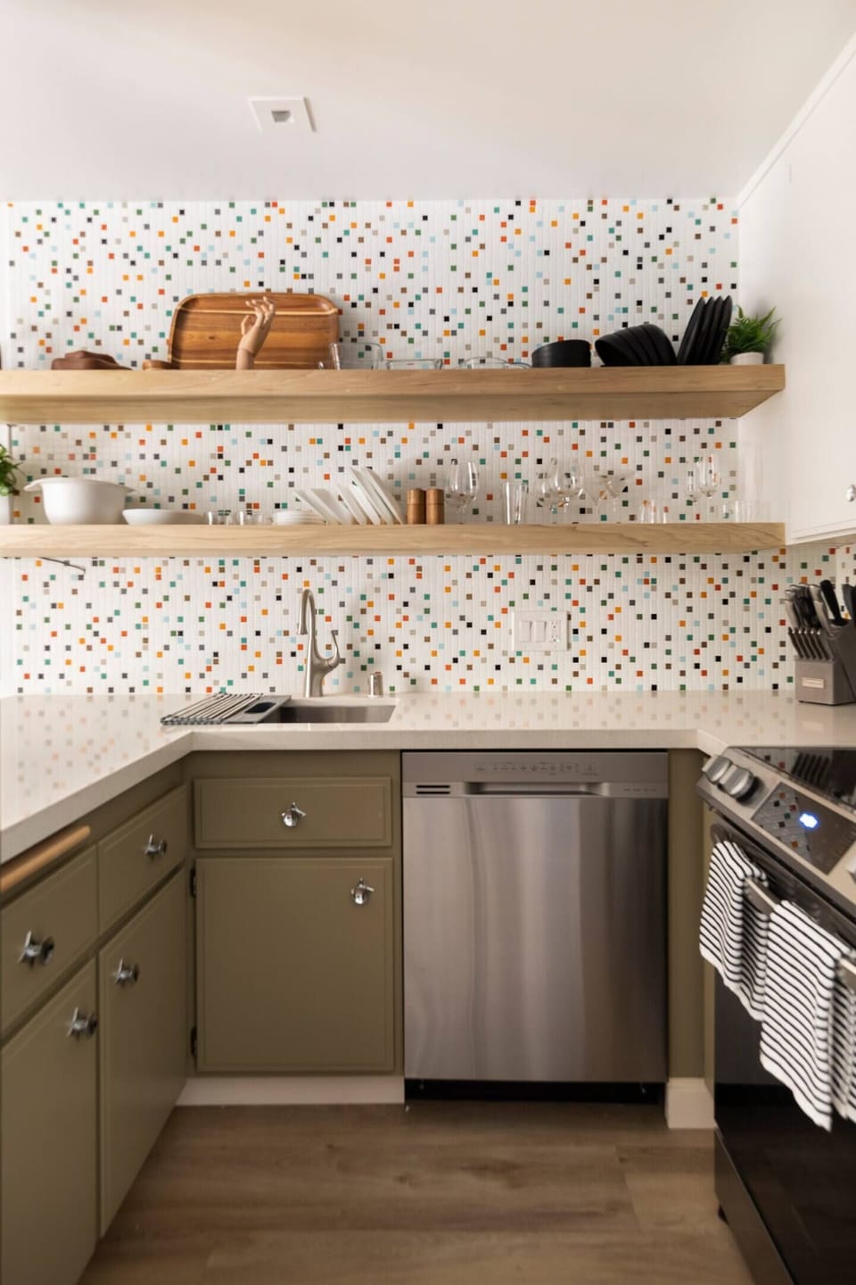 Kitchen with open shelving and new stainless appliances.