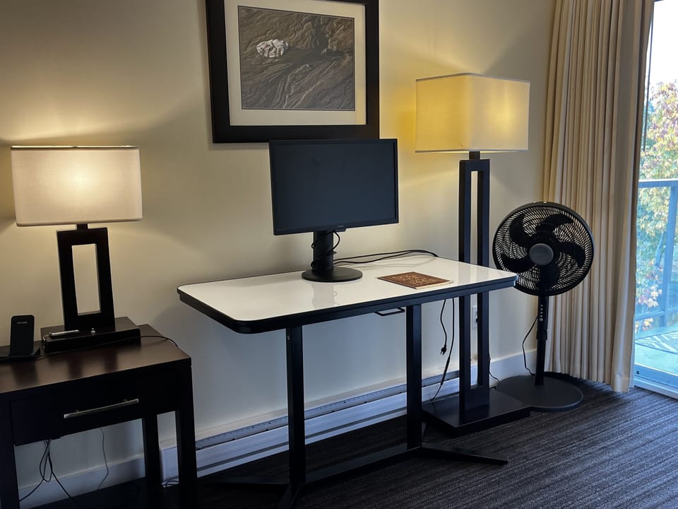 Workspace in master bedroom with adjustable table and monitor