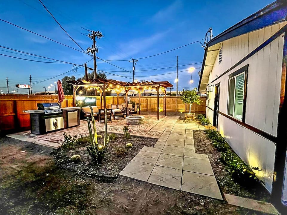 Outdoor pergola, grill, and fire pit at sunset