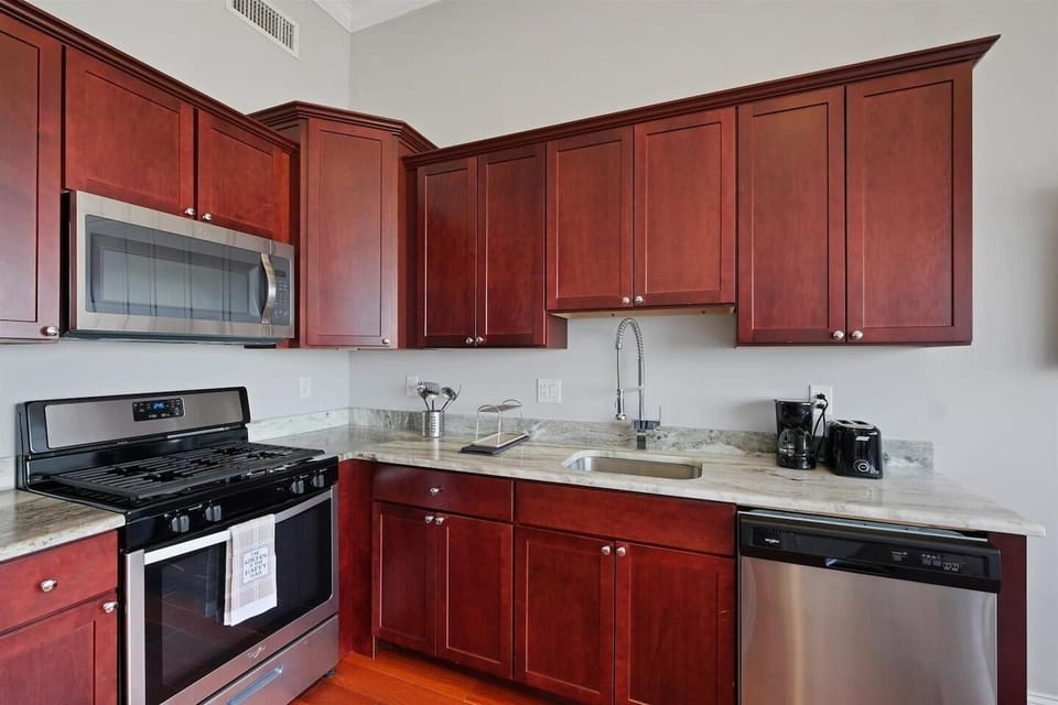 Kitchen featuring granite countertops, stainless refrigerator, and complete cookware for meal preparation.