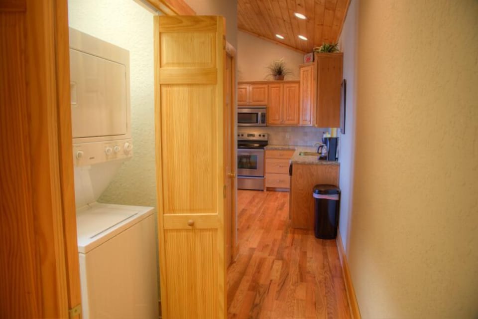 Laundry closet in hall outside bath with stack washer and dryer