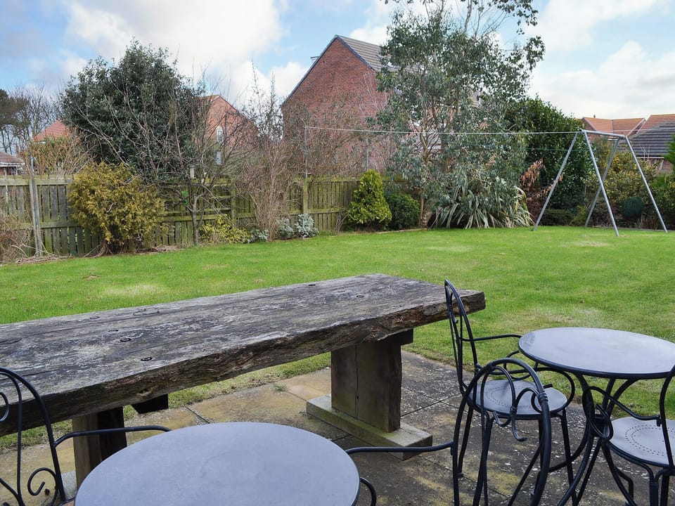Sunny paved patio with seating and table | Sand Castles, Seahouses