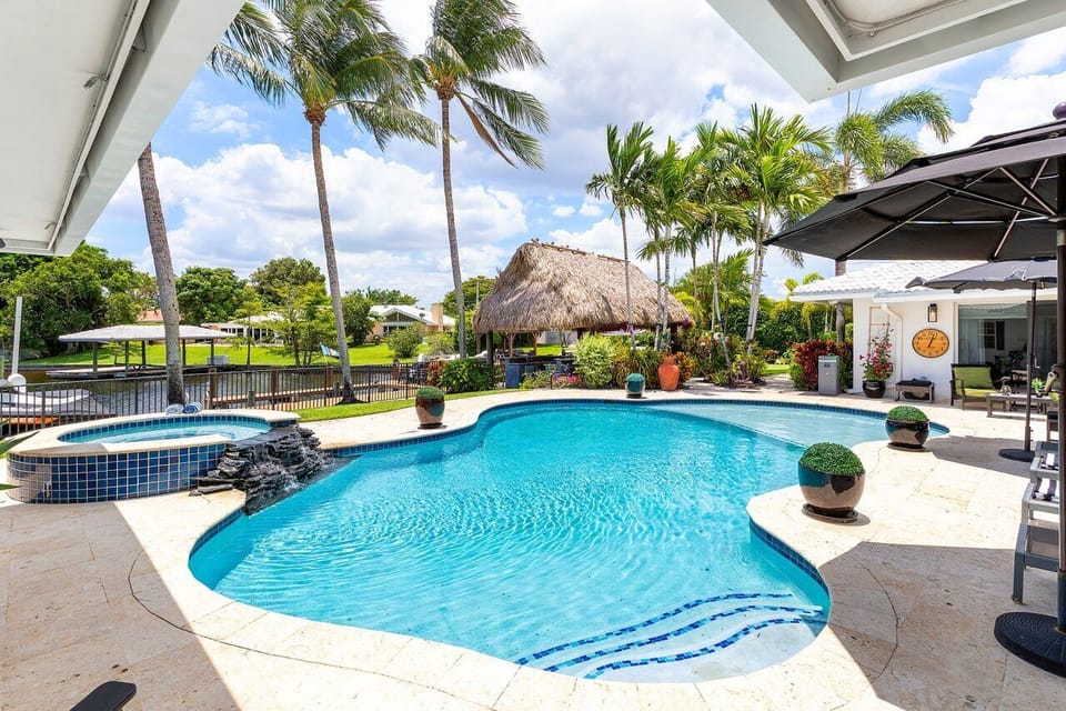 Welcome to your serene backyard oasis, featuring a tranquil setting with lush landscaping, an inviting pool, and a relaxing atmosphere.