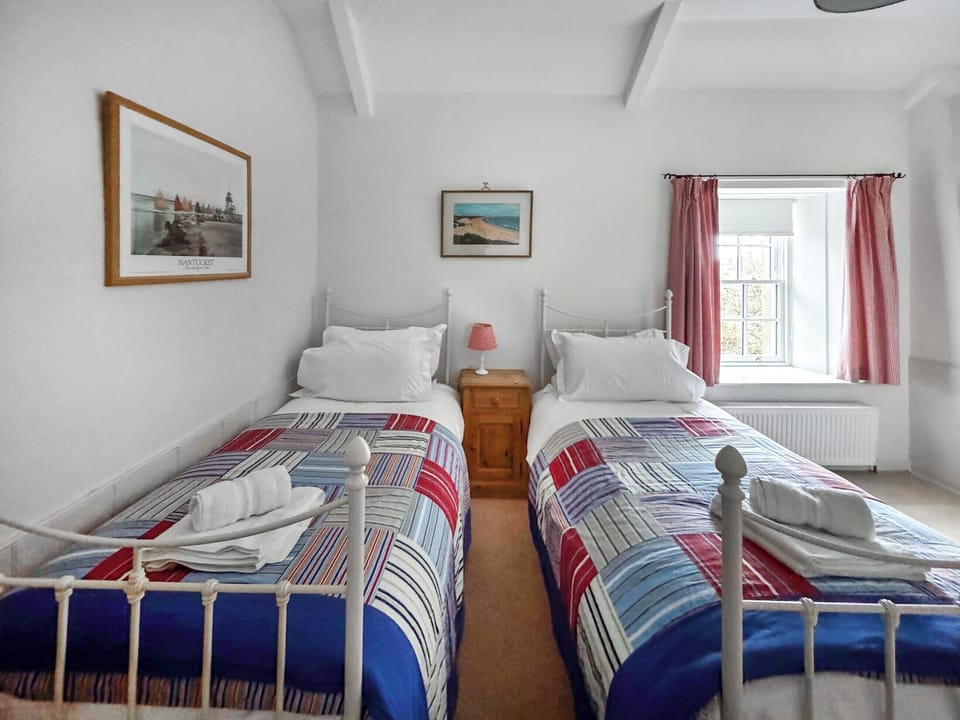 erful twin bedroom with traditional iron frame beds and cosy bedding | Fallodon Burnhouses, near Beadnell