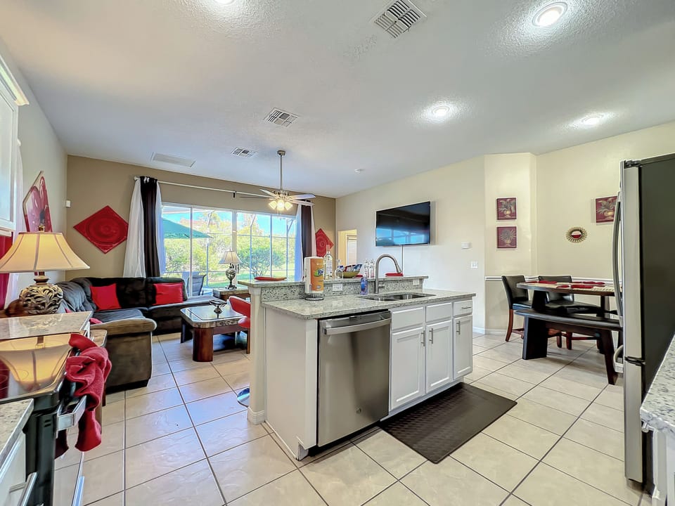 Living area and kitchen with TV and views of the pool 📺