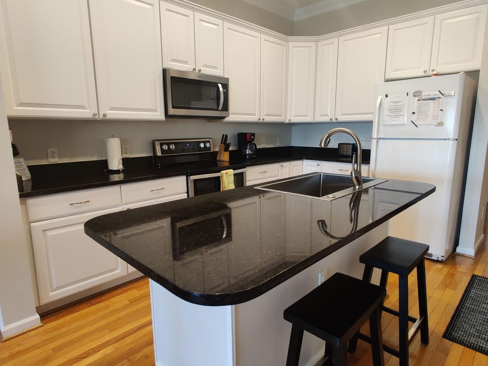 Well equipped kitchen for meal preparation with 2 stools for additional seating.